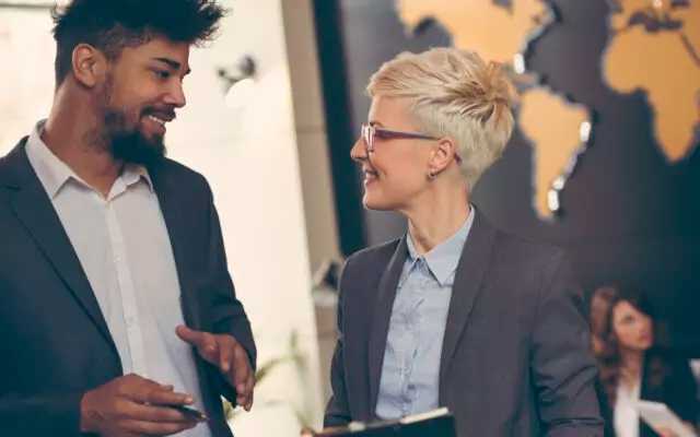 two professional people having a conversation in an office setting