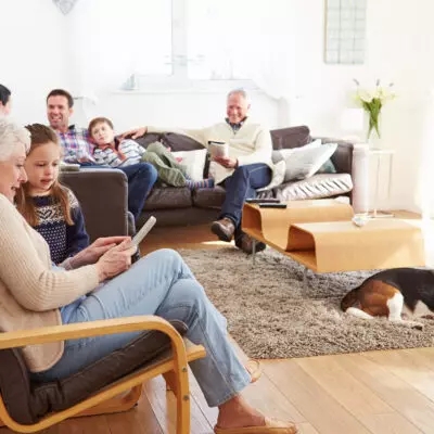 a multigenerational family sits in their living room talking and reading