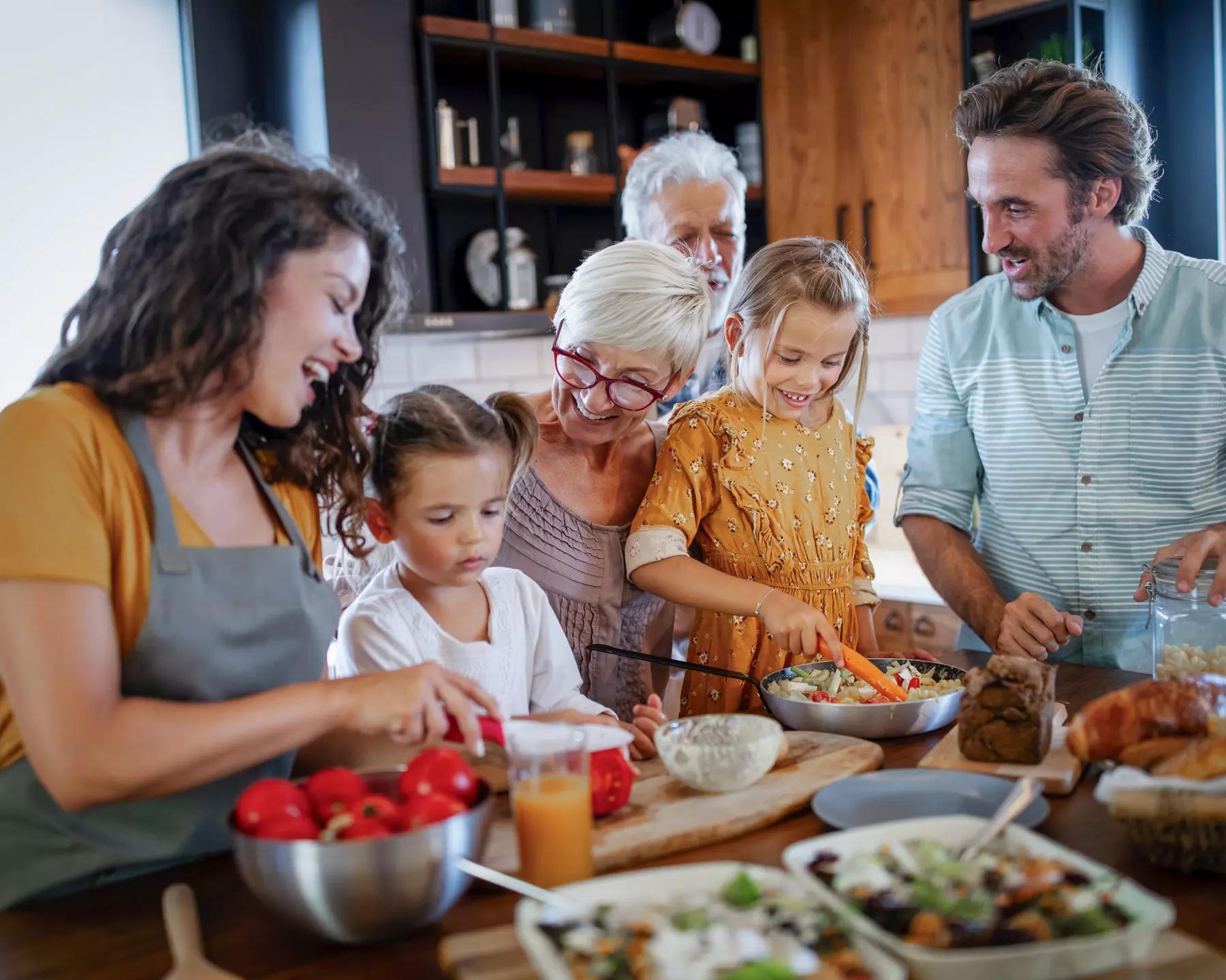 multi-generational family working in the kitchen cooking dinner together creating a lasting legacy of generosity