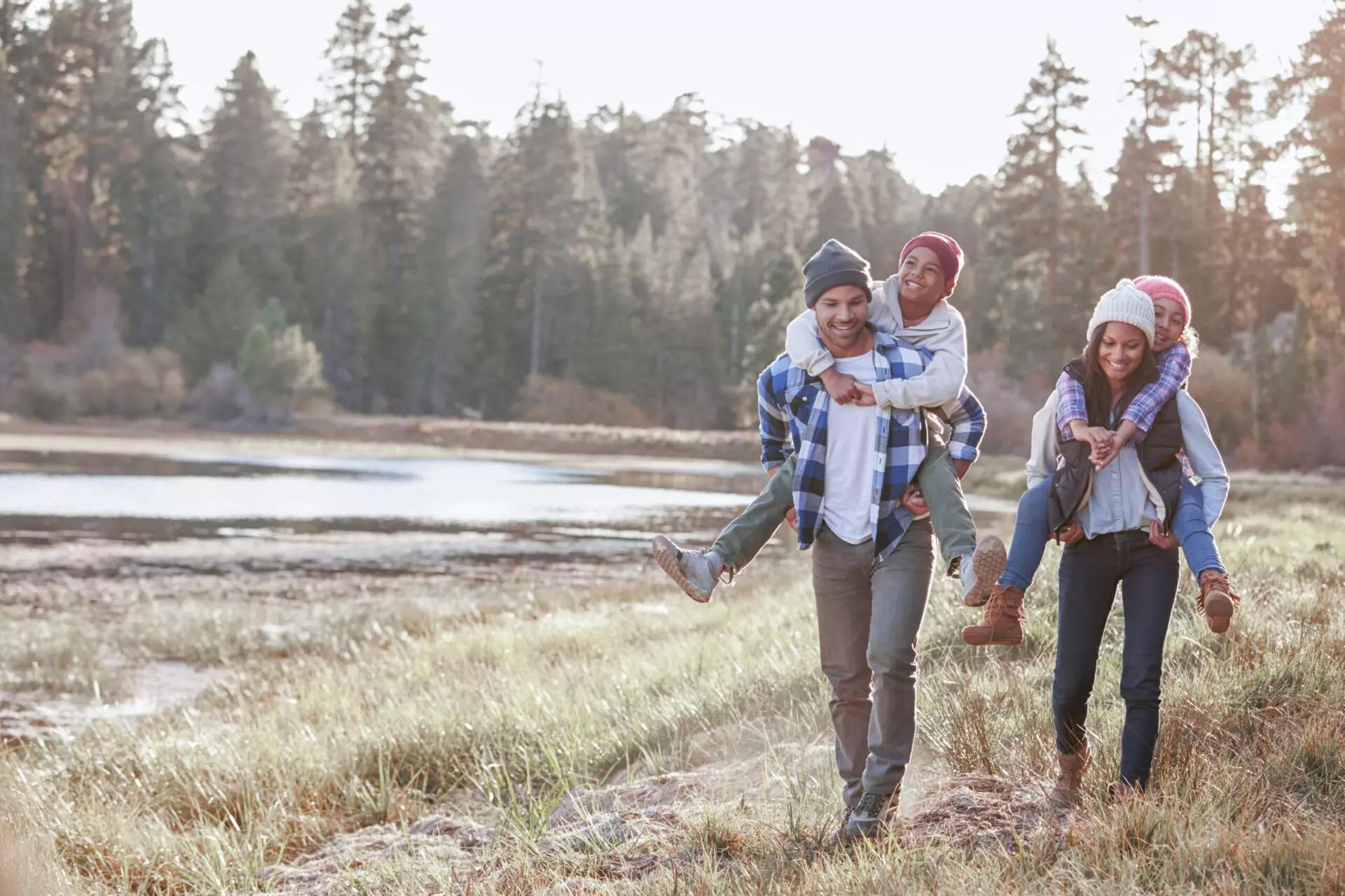 family of four walking through the forest together